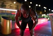 African American Runner Resting On Night Street Stock Photos