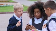 African-American Schoolgirl Shows Smartphone To Friends Stock Footage