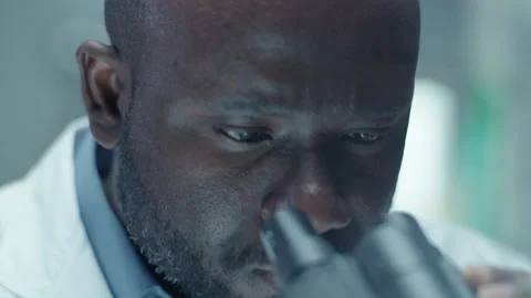 African American Scientist Looking through Microscope in Medical Laboratory Stock Footage 275478357
