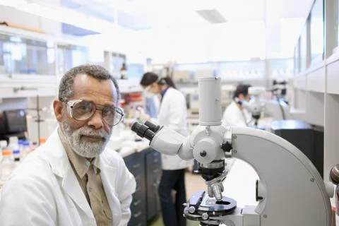 African American scientist using microscope in laboratory 库存照片