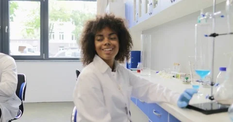 African American Scientist Woman Looking At Test Tubes Rack With Team Of Stock Footage