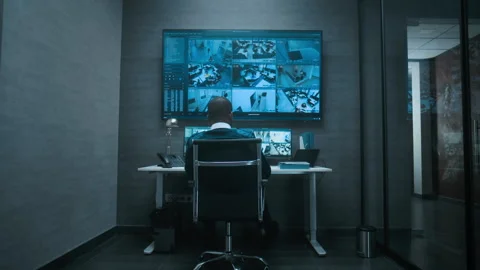 African American security worker controls CCTV cameras on computer and big Stock Footage 281718676