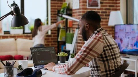 African american software developer works on programming code on a laptop 스톡 사진
