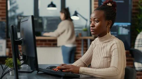 African american software engineer working focused looking at computer screen 스톡 사진