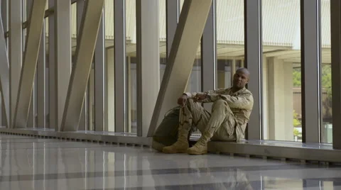 African American soldier sitting in airport Stock Footage