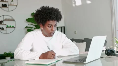 African American student elearning virtual study class, writing notes at home. Video stock 231635895