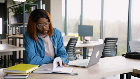 African American student taking notes while studying in library Stock Footage 300503513