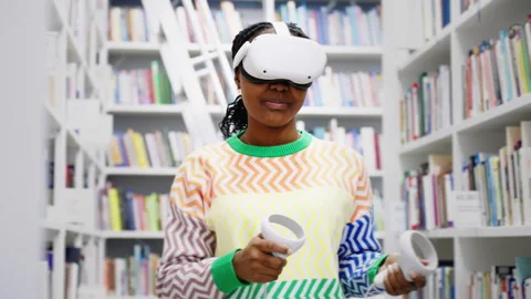 African American student using virtual reality glasses in the library Stock Footage 244845172