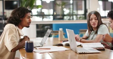 African American students studying at table while right man showing striped Stock Footage 338062684