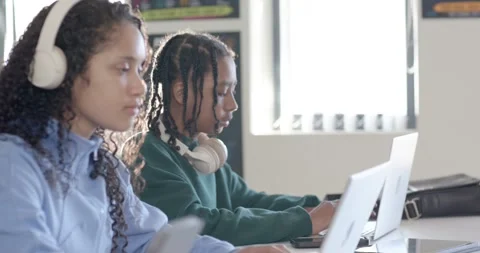 African American students typing on silver laptops at school table with Stock Footage 341029315
