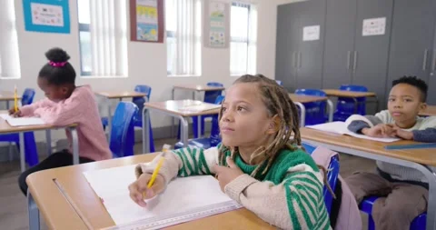 African American students writing in class, center student pausing with yellow Stock Footage 340631431