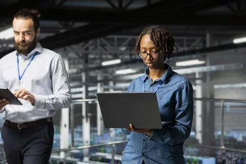 African american system administrator using laptop to review machine learning 库存照片