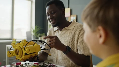 African American Teacher Explaining Robotic Technology to Boy in Stem Class Stock Footage 340550358
