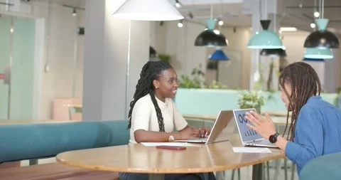 African American team checking charts at round table, right peer gesturing, left Stock Footage 337400210