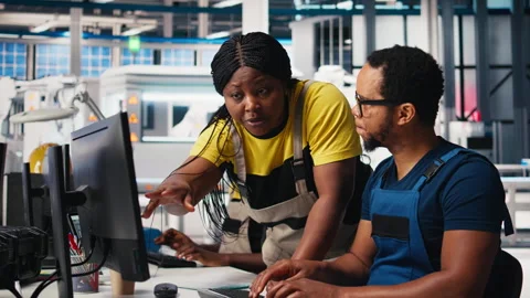 African american team programs robotic arms in solar panel facility Video stock 309075905
