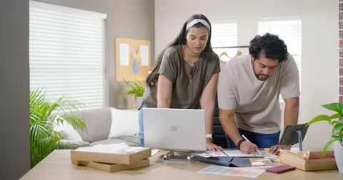 African American team sorting samples at home studio writing and checking laptop Stock Footage 345589197
