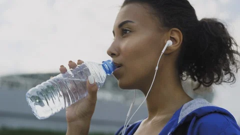 Teen girl drinking water from bottle in summer park. Drinking water in the  heat concept. Close-up Stock Video Footage by ©lizaelesina #489034632