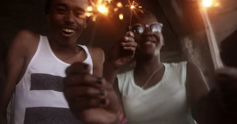 African American teens celebrating happily with sparklers Stock Footage