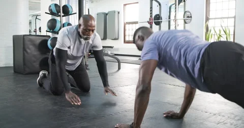 African American trainee doing pushups, doing spider crawl after high-five for Stock Footage 314029616