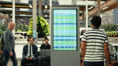 African american traveler checking timetable on departure board in bus terminal Stock Footage 334720902