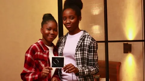African american two happy future mothers sonogram image at home in evening Stock Footage 170067925