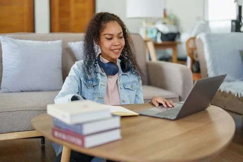 African American using a notebook and computer to study online at home 스톡 사진