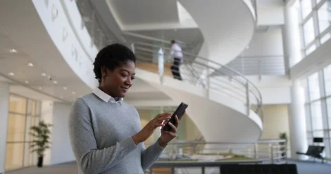 African American using smartphone in modern office Stock Footage 88595166