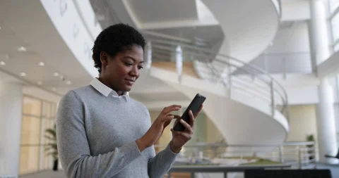 African American using smartphone in modern office Stock Footage 88595174