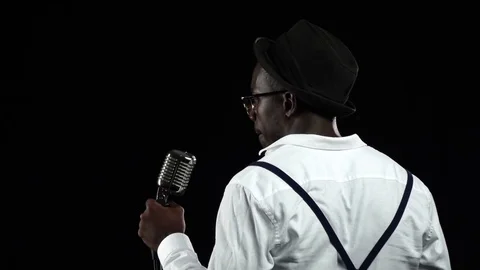 African American the view from the back standing at the microphone singing in a Stock Footage