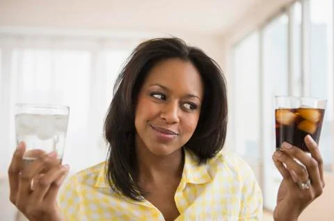 African American woman choosing water or soda Stock Photos