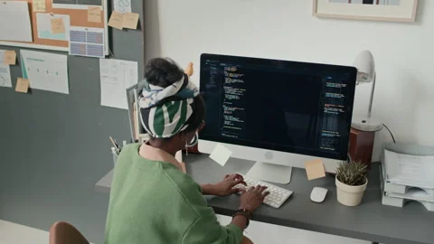 African American Woman Coding on Computer at Cluttered Desk in Modern Office Stock Footage 333212913