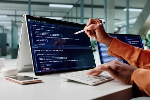 African American Woman Coding On Multiple Monitors In Office Setting. Stock Photos