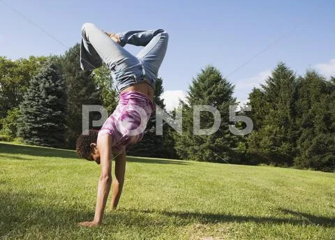 African American woman doing handstand Stock Photos