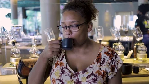 African American woman is drinking coffee in a café very happily Stock Footage
