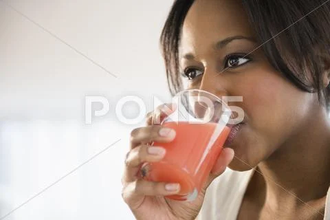 African American Woman Drinking Glass Of Juice