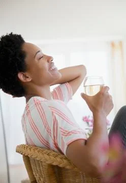 African American woman drinking white wine Stock Photos