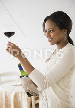 African American woman having glass of wine Stock Photos