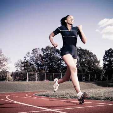 African American woman running on track Stock Photos
