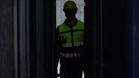 African american worker holding computer laptop walking through container b.. Stock Footage 248349341