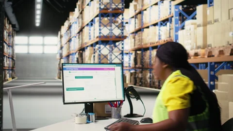 African american worker processing e-commerce cargo orders in warehouse setting Stock Footage 312836815