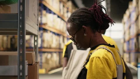 African american worker processing merchandise for business logistics system Stock Footage 315704464
