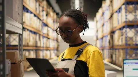 African american worker processing merchandise for business logistics system Stock Photos