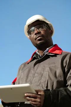 African american worker with tablet computer stands at construction site Stock Photos