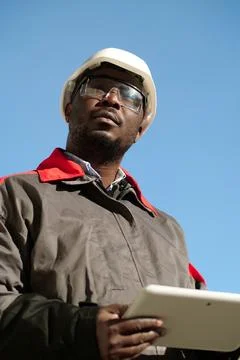 African american worker with tablet computer stands at construction site Stock Photos