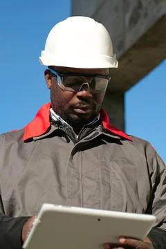 African american worker with tablet computer stands at construction site Stock Photos