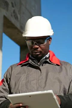 African american worker with tablet computer stands at construction site Stock Photos