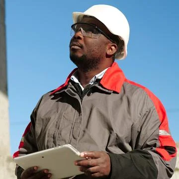 African american worker with tablet computer stands at construction site Stock Photos