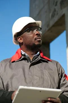 African american worker with tablet computer stands at construction site Stock Photos