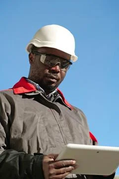 African american worker with tablet computer stands at construction site Stock Photos