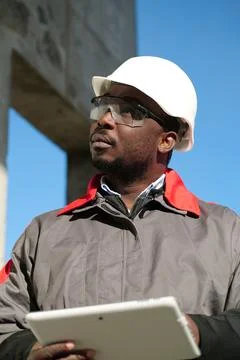 African american worker with tablet computer stands at construction site Stock Photos